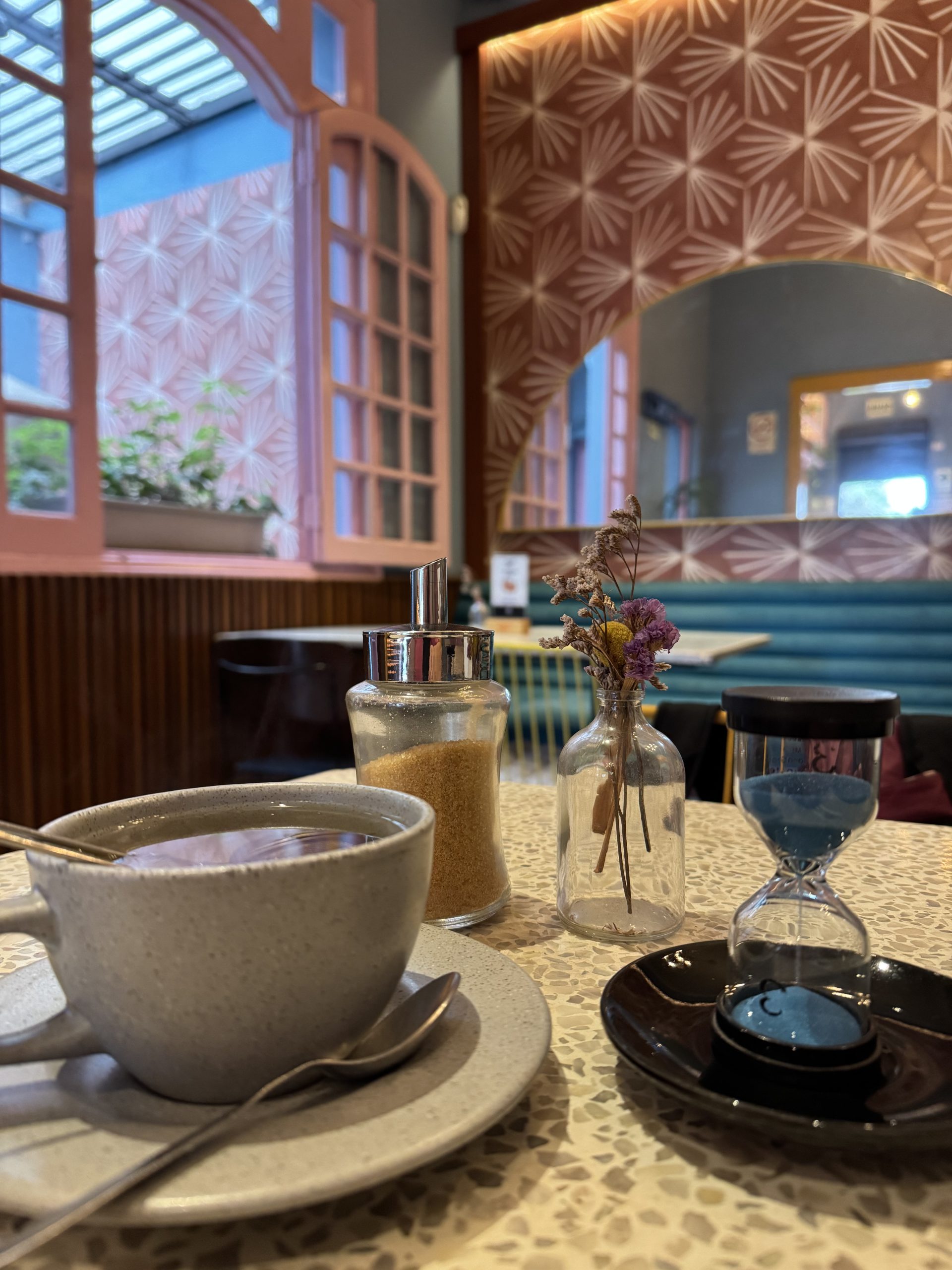 Cup of tea with a small blue sand timer on the table at Ché Chá in Miraflores
